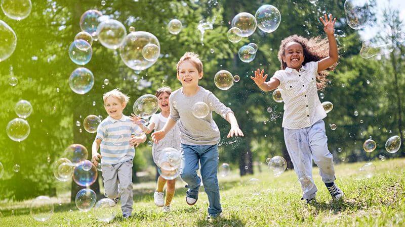 10-ways-to-get-your-child-moving-group of children running in park with soap bubbles