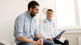 Man sitting at a doctor's office with a provider next to him