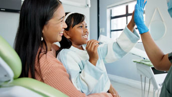 Young girl doing a high five with a pediatric provider