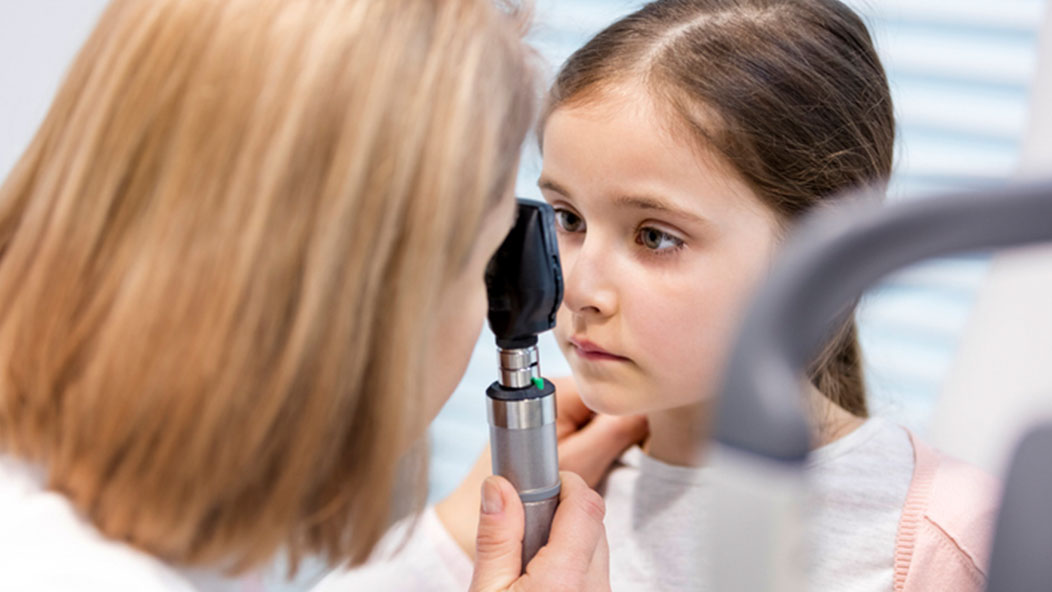 Doctor checking checking child's eye for pink eye