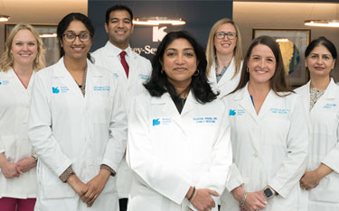 Kelsey-Seybold physicians posing confidently inside a clinic foyer