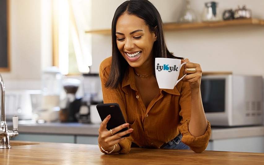 Kelsey-Seybold patient holds mug with IYKYK logo.