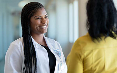 Chiropractic Care specialist Raven Atkins, DC, laughs with a patient.