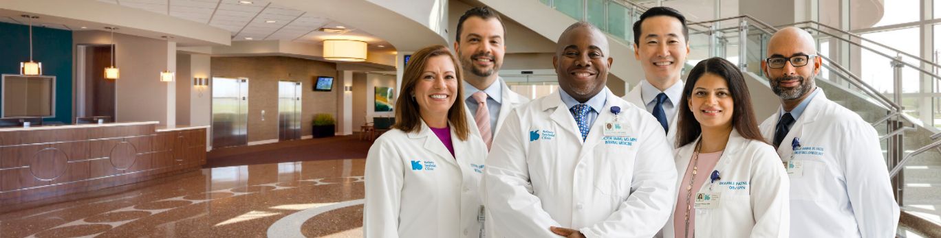 Kelsey-Seybold doctors stand smiling in a clinic lobby.