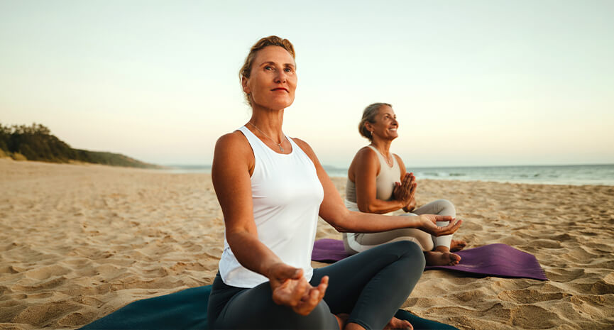 Women doing yoga on the beach