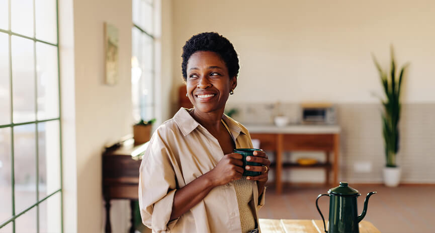 Woman holding a mug in her kitchen