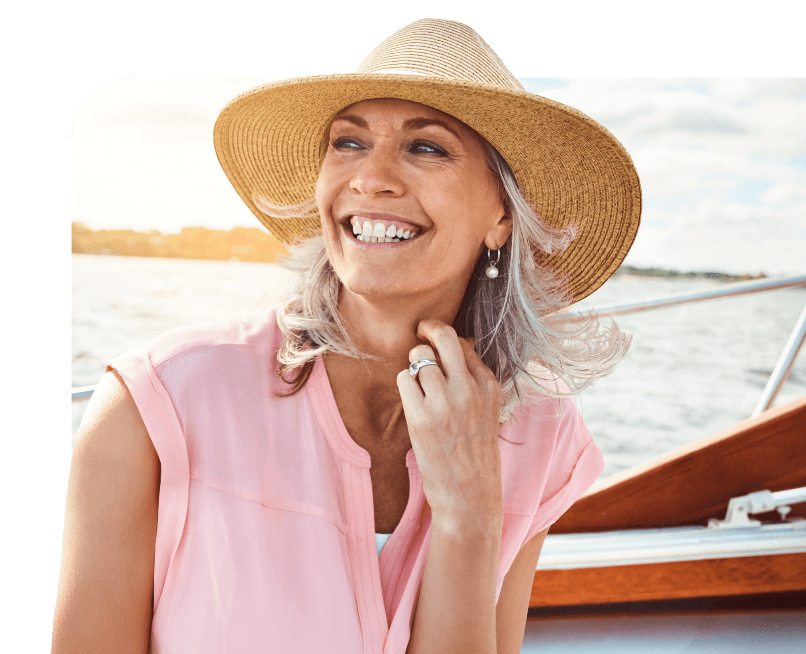 Smiling woman in a sun hat on a boat